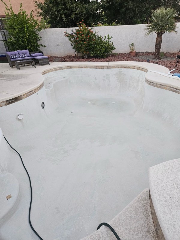 An empty, freshly cleaned white pool in a Las Vegas backyard